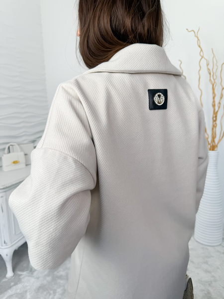 Beżowy płaszcz ze sweterkowymi rękawami